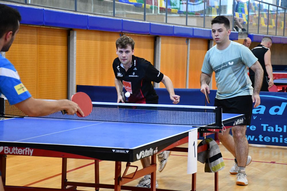 Partit de dobles en marxa: la parella al fons espera el servei amb la mirada fix